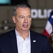 ICE-chefen Todd Lyons med Kristi Noem i bakgrunden. Bild från oktober. 