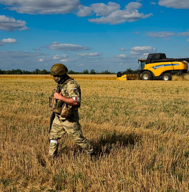 A Russian soldier guards an area during foreign journalists watch and film as farmers of the Voznesenka-Agro farm harvest with their combine in a wheat field not far from Melitopol, south Ukraine, Thursday, July 14, 2022. AP
