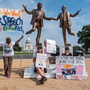 Demonstranter vid en staty av Trump och Epstein.