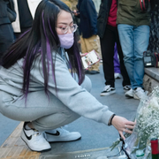 En kvinna lägger blommor vid en minnesplats/bild från en av de många videoklipp som spreds av trängseln som föregick tragedin.