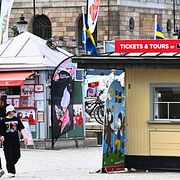 Turister njuter av värmen på Skeppsbron i Stockholm, där biljetter och glass säljs.