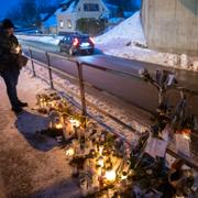 Blommor, ljus och föremål på minnesplatsen under en viadukt i Örkelljunga efter mordet.