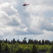 En helikopter bärgar vrakdelar efter olyckan.