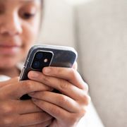 Flicka kollar sociala medier på sin mobil.