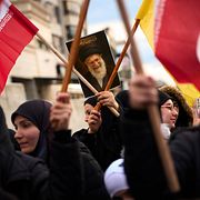 Tidigare högste ledaren ayatollah Ali Khameneis porträtt hålls upp under en protest i Beirut.