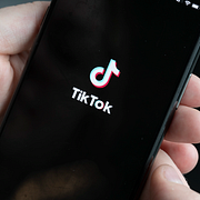 Mobiltelefon med  Tiktok/genrebild på skolgård
