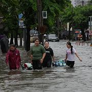 Invånare vadar genom vatten i centrala Bangkok.