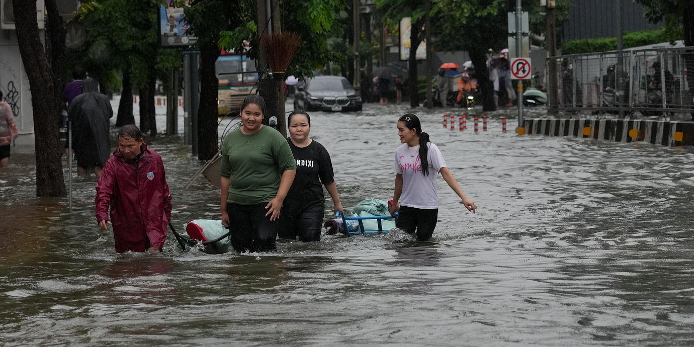 Invånare vadar genom vatten i centrala Bangkok.