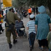 Bilden visar en israelisk soldat med en barnvagn i Jerusalem, skriver AP.