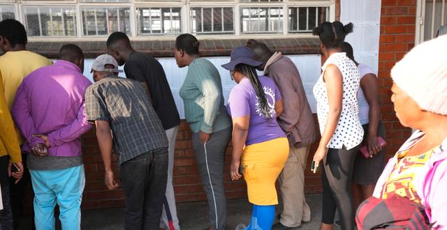 Folk letar efter sina valsedlar utanför en vallokal i Zimbabwes huvudstad Harare. Tsvangirayi Mukwazhi / AP