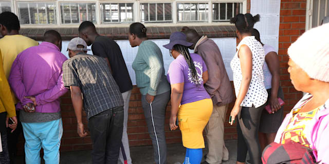 Folk letar efter sina valsedlar utanför en vallokal i Zimbabwes huvudstad Harare. Tsvangirayi Mukwazhi / AP