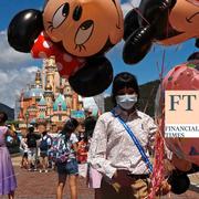 An employee wearing a face mask to prevent the spread of the new coronavirus, sells balloons at the Hong Kong Disneyland.