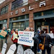 Protester utanför en bilutställning med Teslabilar i Seattle. 