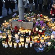 Sörjande samlas för att placera blommor och ljus utanför Risbergska skolan i Örebro. 