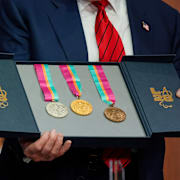 USA:s president Donald Trump håller upp medaljer från OS 1984