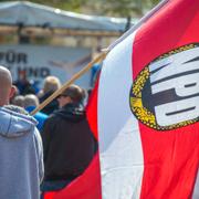 En man med en NDP-flagga deltar i en demonstration i Schwerin i Tyskland, 1 maj 2016.