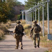 Två ryska soldater patrullerar i Donetsk. 