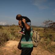 En man som flytt Venezuela tillsammans med barn vid gränsen till Brasilien. 