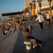 En man spelar musik på stranden i Tel Aviv den 4 november.