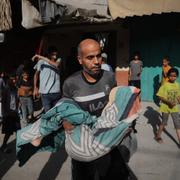 Palestinsk man bär på tolvårig pojke i Zawaida, centrala Gaza, på torsdagen.