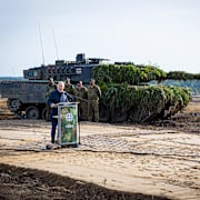 Olaf Scholz talar intill en Leopard 2-stridsvagn. Moritz Frankenberg / AP