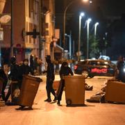 Upploppsmakare blockerar en gata med soptunnor i Colombes utanför Paris på lördagen. 