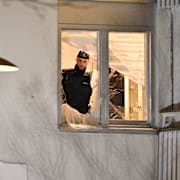 Poliser i en av lägenheterna som skadades i explosionen.