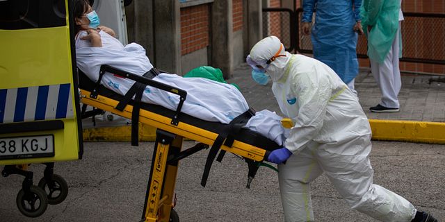 Sjukvårdare lyfter bår med patient i Spanien.  Bernat Armangue / TT NYHETSBYRÅN