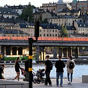 Människor promenerar längs en nyrenoverad kaj vid Munkbroleden i Gamla stan i Stockholm.