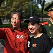 Två kvinnor tar selfies i samband med militärparaden i Peking under 70-årsfirandet av Folkrepubliken Kina.