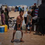 Palestinier samlas för att hämta vatten från en lastbil under en värmebölja i ett provisoriskt tältläger i Khan Younis, Gazaremsan, onsdagen den 13 augusti 2025.