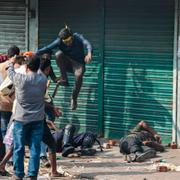 Aktivister attackerar säkerhetspersonal i Dhaka under lördagens protester. 