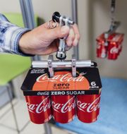 The KeelClip, a paperboard yoke for carrying cans, is tested in a company lab. KENDRICK BRINSON FOR THE WALL STREET JOURNAL