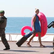 Arkivbild: Semestrande kvinna möter soldater på strandpromenaden i Nice.