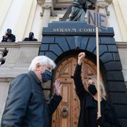 En kvinnlig demonstrant håller ett plakat med texten ”nej” framför en kyrka i Warszawa.