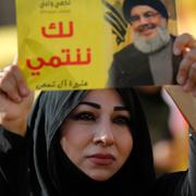 En Hizbollah-supporter håller upp en bild på gruppens ledare Sayyed Hassan Nasrallah. 