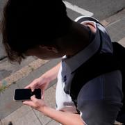 En pojke kollar sin telefon i Sydney i Australien. Arkivbild. 