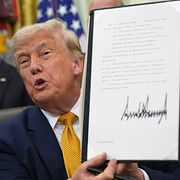Trump håller upp en av de undertecknade ordrarna om kvantdatorer.