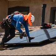 Sunpowers Jose Arrechiga installerar solpaneler på ett hus i Pasadena i Kalifornien. Arkivbild från juli 2023.