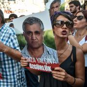 Människor med bilder på Hamza Yalcin protesterar mot gripandet i Istanbul 13 augusti.