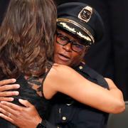 Michelle Obama omfamnar polischefen David Brown, Barack Obama till höger.