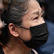 En sörjande kvinna utanför puben i Bangkok där en våldsam brand bröt ut natten till måndagen.