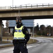 Polis i gasmask under larmet vid Säpo i fredags.