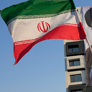 Till vänster: En kvinna viftar med den iranska flaggan i Teheran. Till höger: Polis i samband med insatsen vid RAF Fairford.