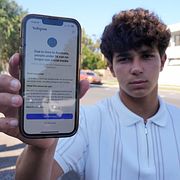 Noah Jones i Sydney visar upp sin mobil, han får inte längre tillgång till sociala medier.