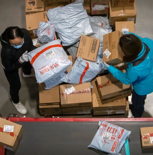  Workers load parcels onto a conveyor belt at a warehouse for online retailer JD.com in Beijing, Wednesday, Nov. 11, 2020. Mark Schiefelbein / AP