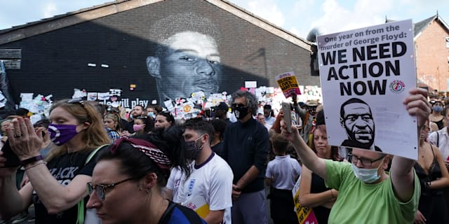 Demonstranter håller upp George Floyds porträtt. Jon Super / AP