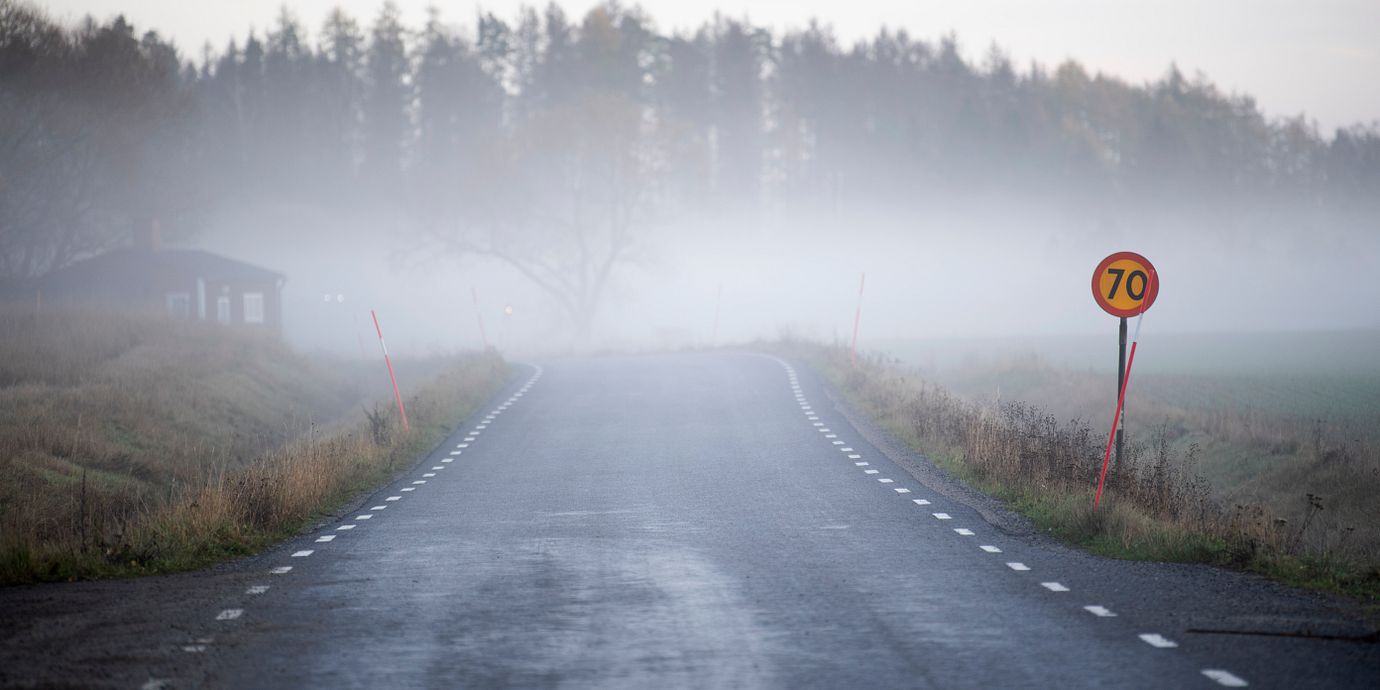 Morgondimma över en öde väg i Uppland.
