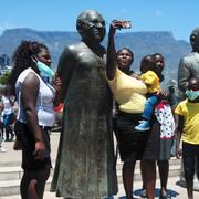 En kvinna tar en selfie vid en staty av Desmond Tutu i Kapstaden. 