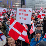 Grönländska och danska flaggor och plakat vid en demonstration på Rådhusplatsen i Köpenhamn i lördags.